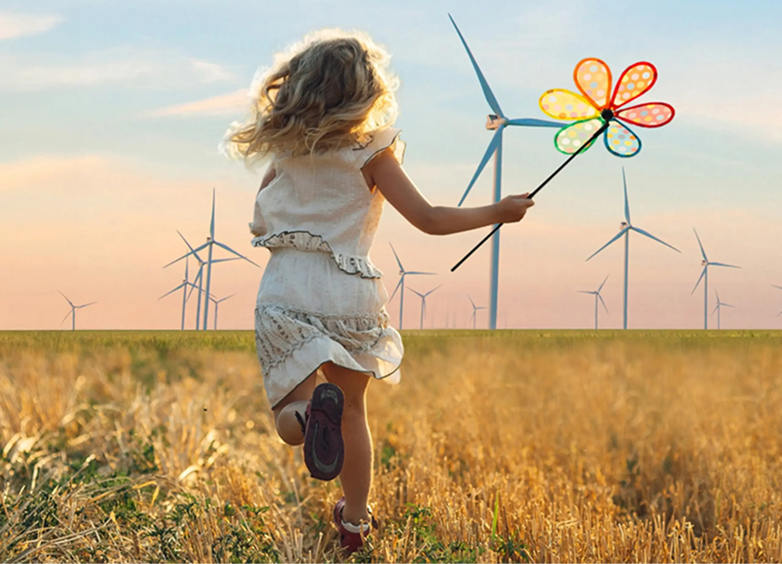Bild von einem Kind mit Windmühle in der Hand auf einem Feld mit Windrädern im Hintergrund