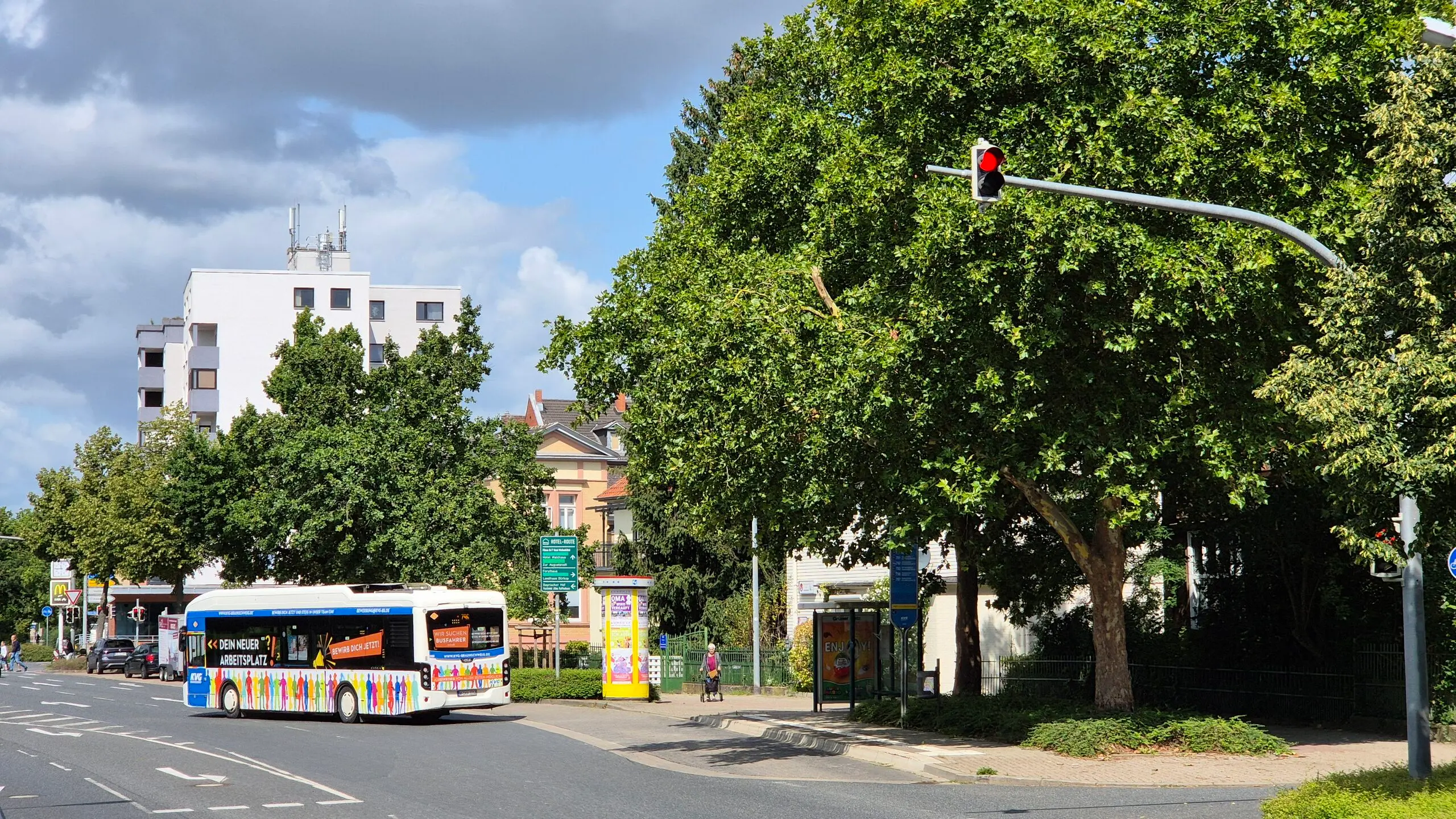 Bus auf Straße in Wolfenbüttel mit roter Ampel im Vordergrund.