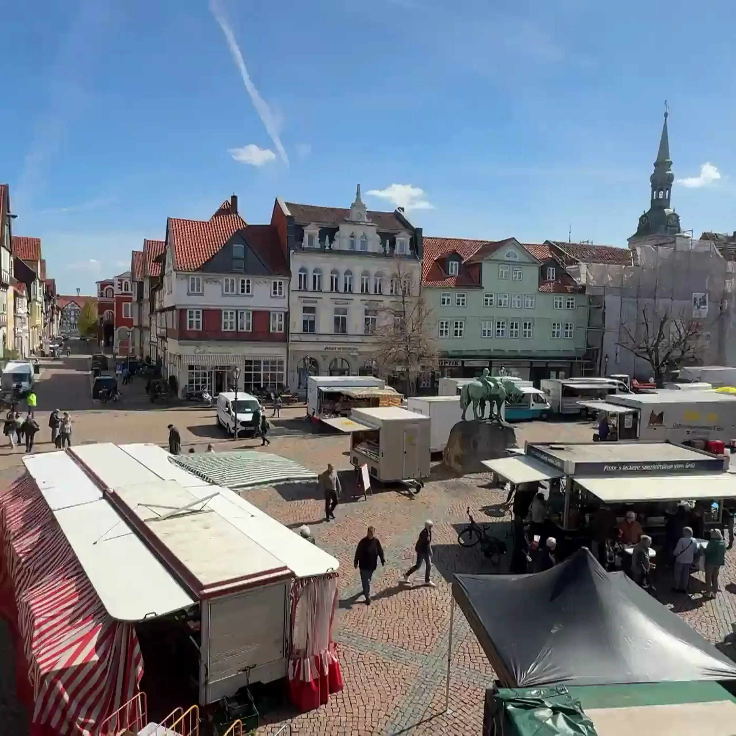 Belebter Wolfenbütteler Marktplatz mit Marktständen und Blick zum Rathausturm.